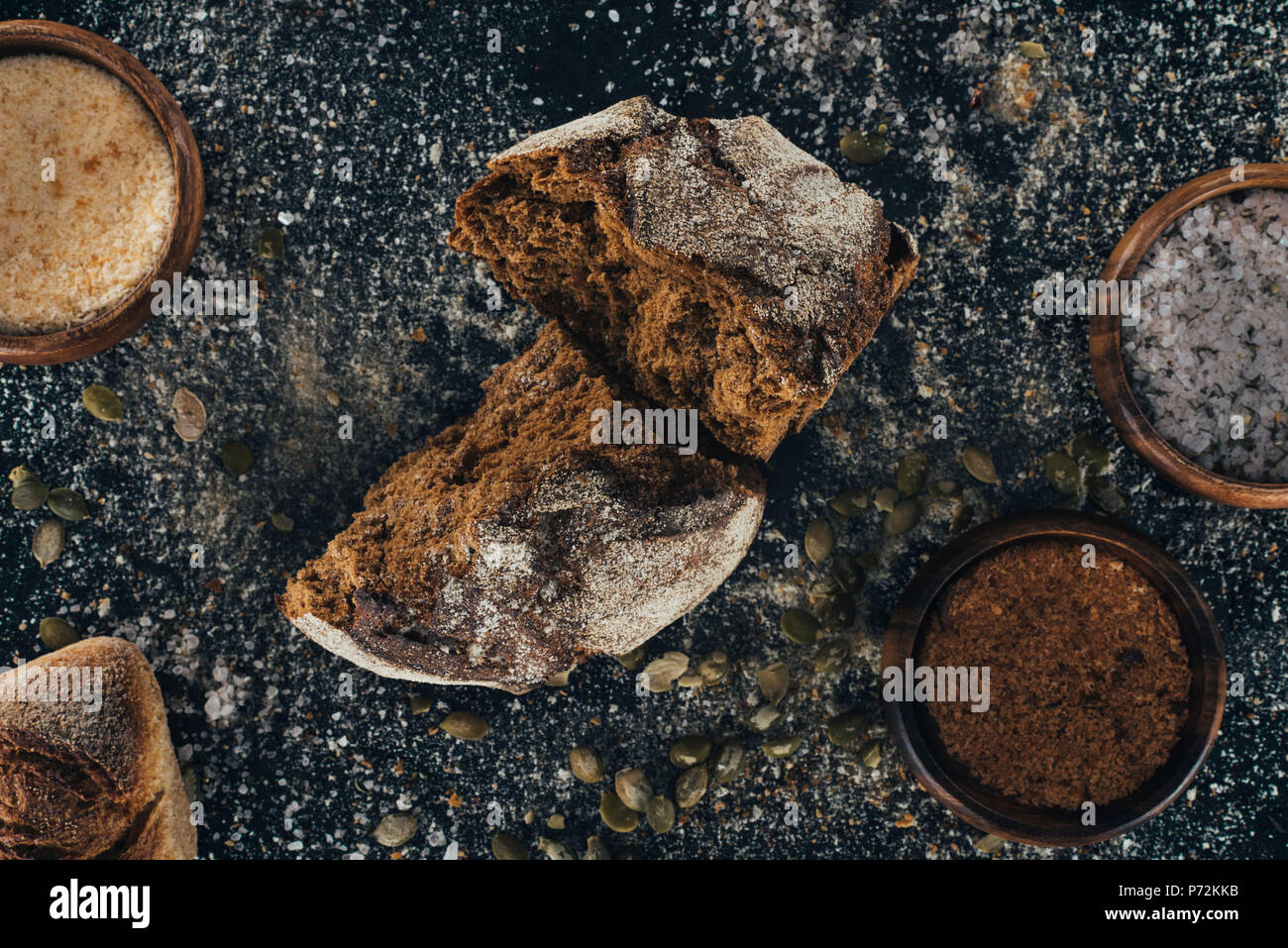 top view of organic homemade bread with spices and pumpkin seeds on black Stock Photo