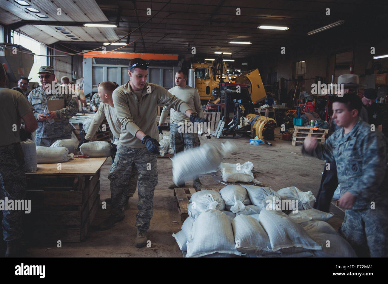 Airmen assigned to the 107th Attack Wing of the New York Air National Guard fill sandbags at the Kendall, N. Y. town garage on May 11, 2017 as part of the New York National Guard response to high water levels in Lake Ontario which resulted in local flooding. Between May 3 and May 13 323 New York National Guard Soldiers and Airmen filled 239, 239,703 sandbags at six locations in counties along the lake. Stock Photo