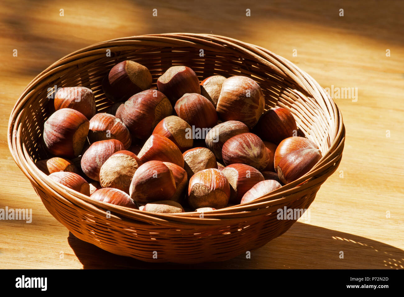 Hazelnuts in a basket on a wooden table Stock Photo