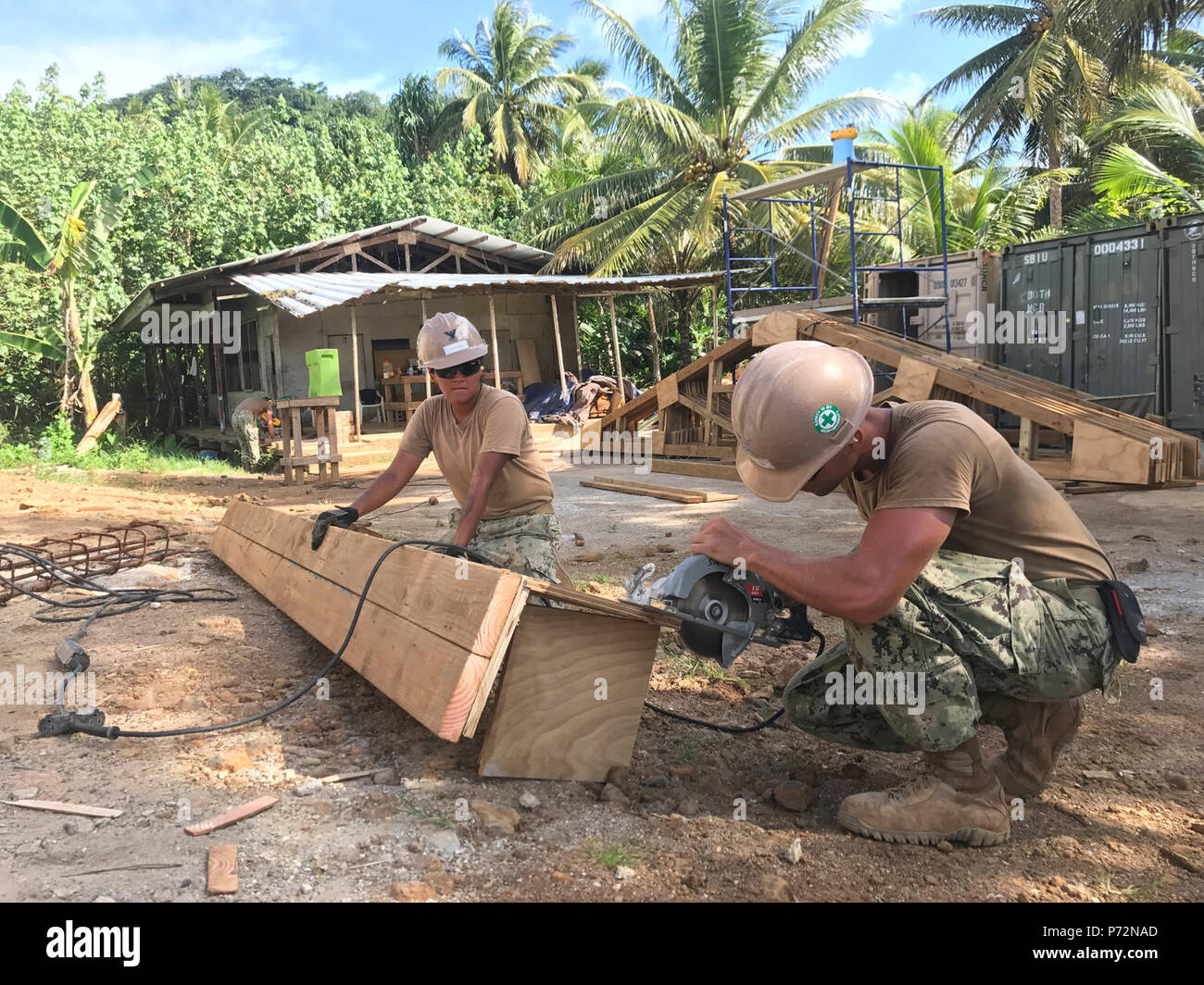 KOSRAE, Federated States of Micronesia (May 11, 2017) From the right, Utilitiesman 2nd Class Christopher Boughton, from Clayton, North Carolina, and Construction Electrician 2nd Class Daniela Acevedo, from Crystal Lake, Illinois,  cut form work for a bond beam for the Naval Mobile Construction Battalion (NMCB) 1 Walung Health Clinic project in Kosrae, Federated States of Micronesia, May 11, 2017. NMCB 1 is forward deployed to execute construction, humanitarian and foreign assistance, special operations combat service support, and theater security cooperation in support of U.S. Pacific Command. Stock Photo