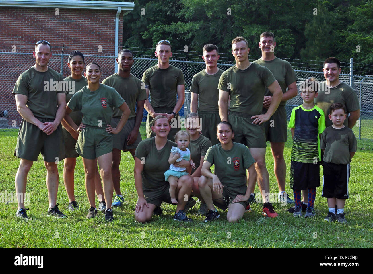 U.S. Marines with Marine Corps Installations East Combat Camera and their family members pose for a group photo after a memorial run to honor fallen combat camera members, Camp Lejeune, N.C., May 11, 2017. Cpl. Sara Medina, a combat photographer, and Lance Cpl. Jacob Hug, a combat videographer, gave the ultimate sacrifice while providing humanitarian assistance and disaster relief to remote villages in Nepal in dire need of aid during Operation Sahayogi Haat. Stock Photo