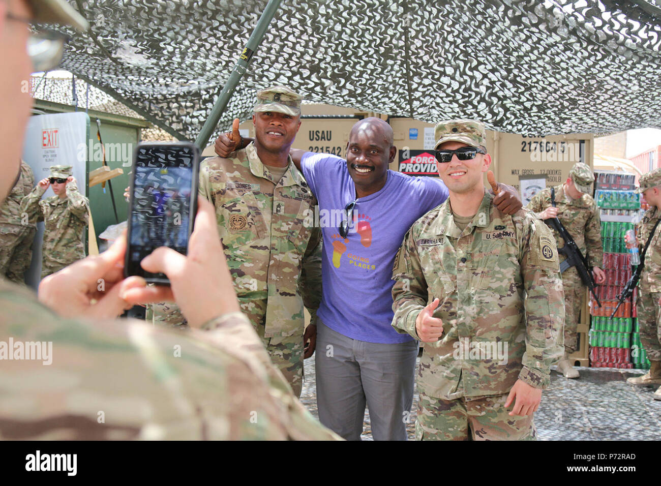 Paratroopers from 2nd BCT, 82nd Airborne Division, pose with stand-up comic, Rawle Lewis, near Makhmour, Iraq, May 11, 2017. Lewis performed as part of the Comedy Comrades Tour, sponsored by Armed Forces Entertainment, the official Department of Defense agency providing entertainment to deployed military personnel. The Paratroopers, deployed in support of Combined Joint Task Force-Operation Inherent Resolve, enable their Iraqi security force partners through the advise and assist mission, contributing planning, intelligence collection and analysis, force protection, and precision fires to achi Stock Photo