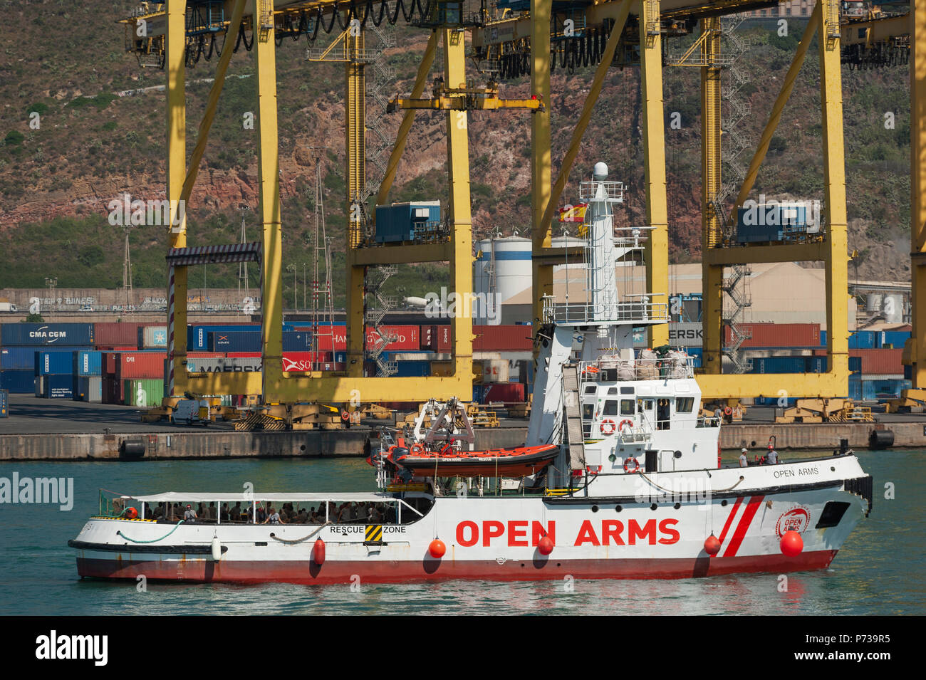 Barcelona. 04th July, 2018.  The Open Arms ship, from the Spanish ONG Proactiva Open Arms, approaches for docking in the port of Barcelona. The humanitarian aid ship sailed to Spain with 60 immigrants from 14 different nationalities rescued on Saturday in waters near Libya, after it was rejected by Italy and Malta. Stock Photo