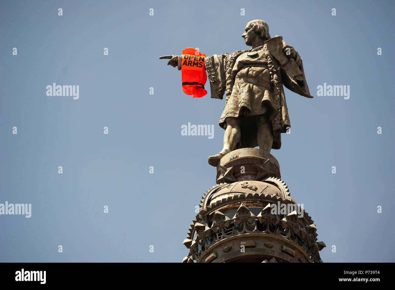 Barcelona. 04th July, 2018.  Activists of the ONG Proactiva Open Arms, have placed a life preserver with the words "Open Arms" in monument Christopher Columbus tower. The activists have carried out this action for Christopher Columbus to call attention to the loss of lives of migrants and refugees in the Mediterranean Sea. Credit: Charlie Perez/Alamy Live News Stock Photo