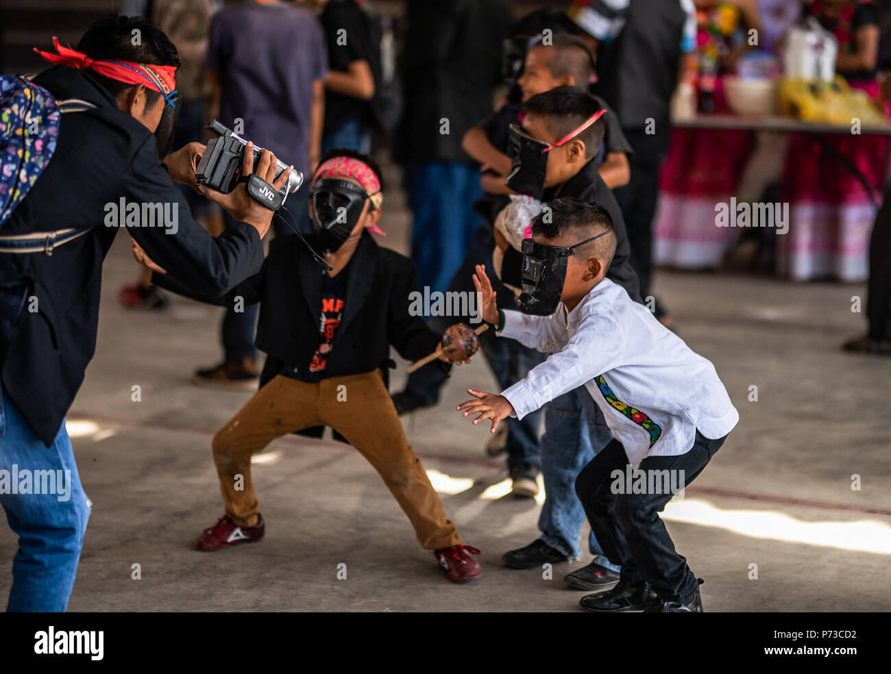 28 June 2018, Mexico, San Pedro Huamelula: Masked children dance on the sidelines of the celebrations in honor of San Pedro. As part of the celebrations, the mayor symbolically married a small reptile. The unusual wedding should give the fishermen a rich catch. Photo: Edgar Santiago Garcia/dpa Stock Photo