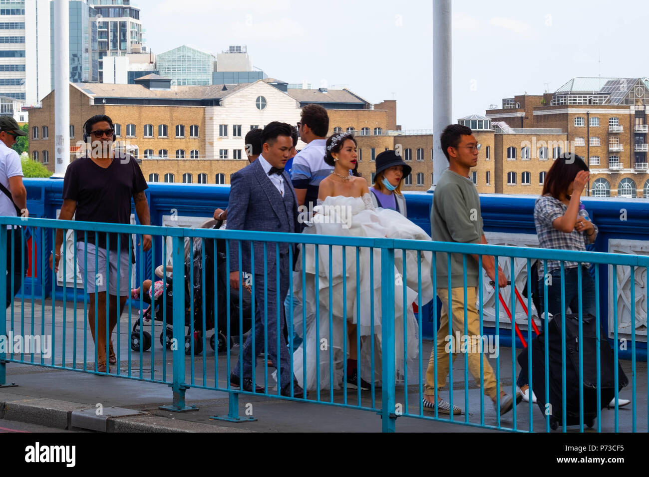 London, England. 4th July 2018. A couple have their wedding photos taken on London's Tower Bridge among all the tourists on another very hot day. The present heatwave is set to continue. ©Tim Ring/Alamy Live News Stock Photo