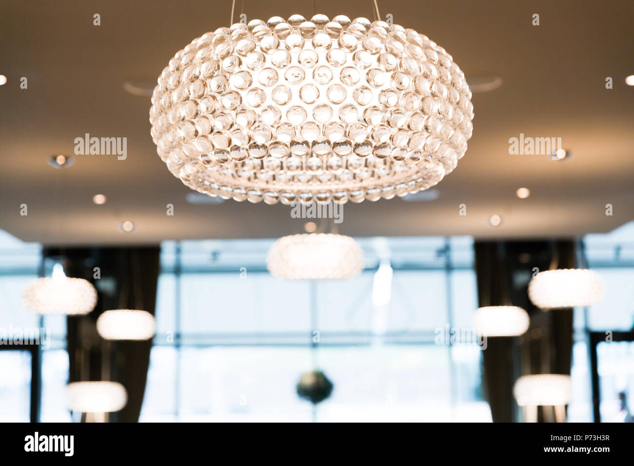Brightly Lit Round Ceiling Lighting in Restaurant with Blurred Background Stock Photo