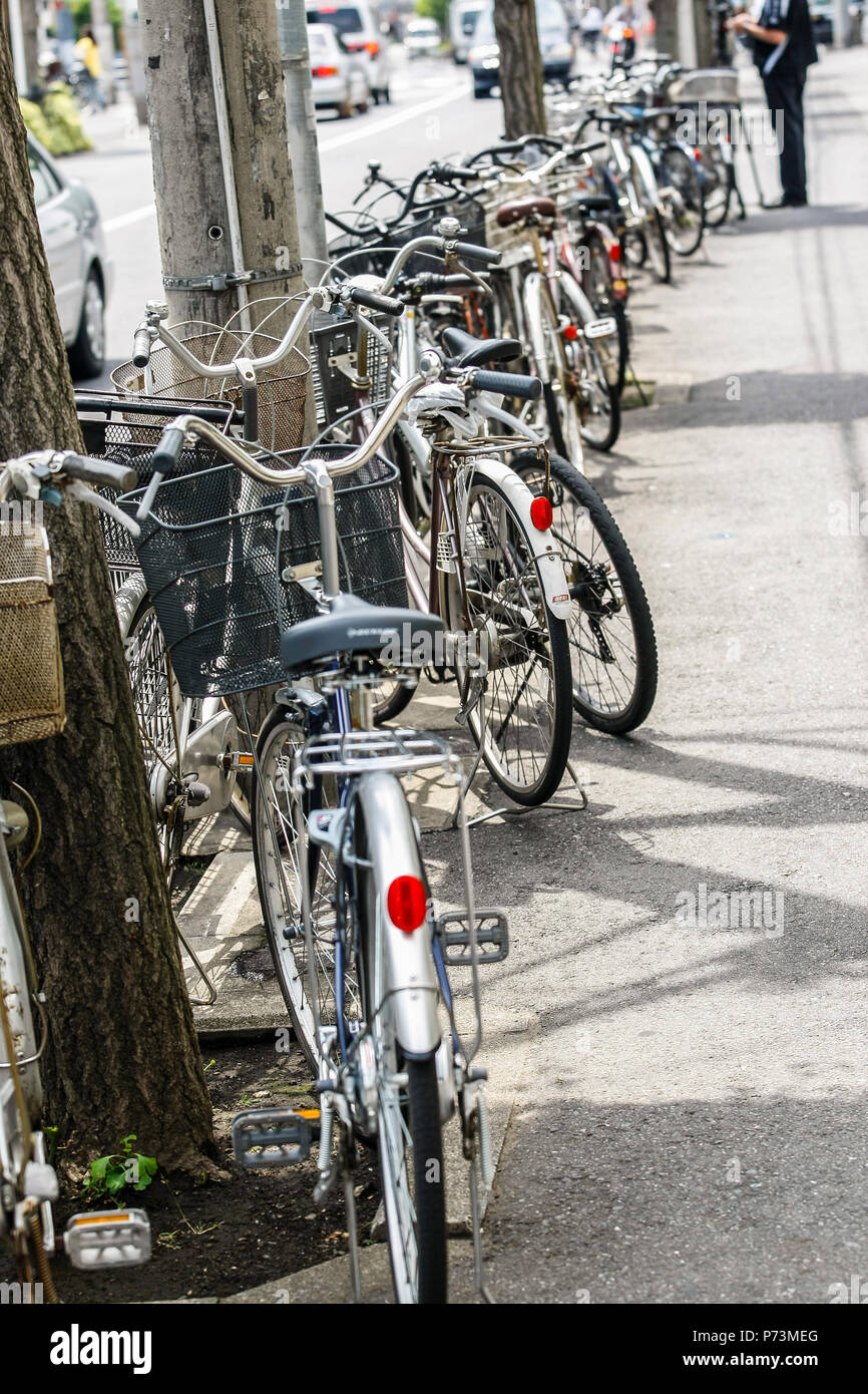 A long line of parked urban bicycles in racks, Omiya, Japan Stock Photo