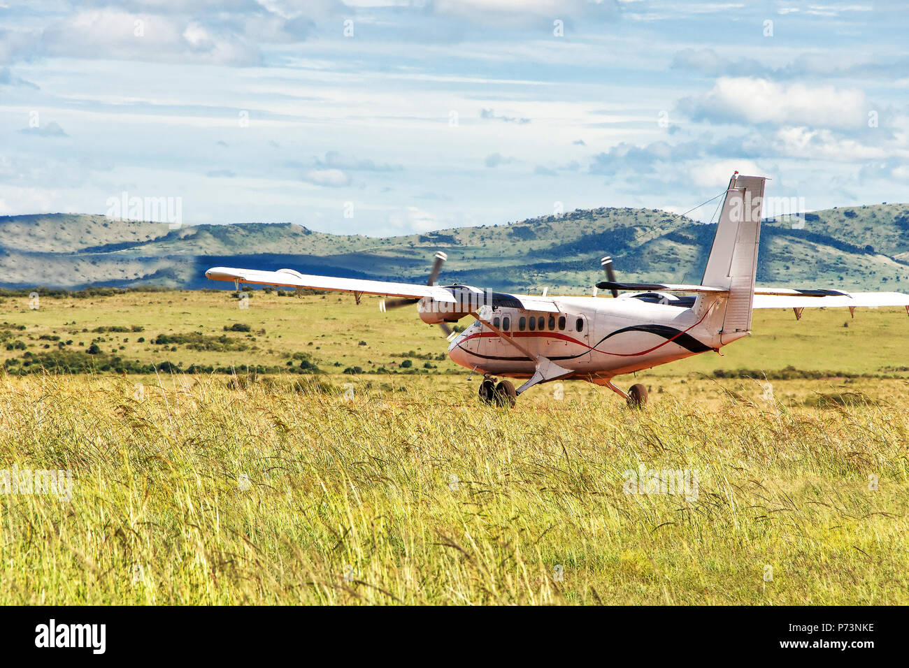 Small passenger propeller plane landed on the green  meadow Stock Photo