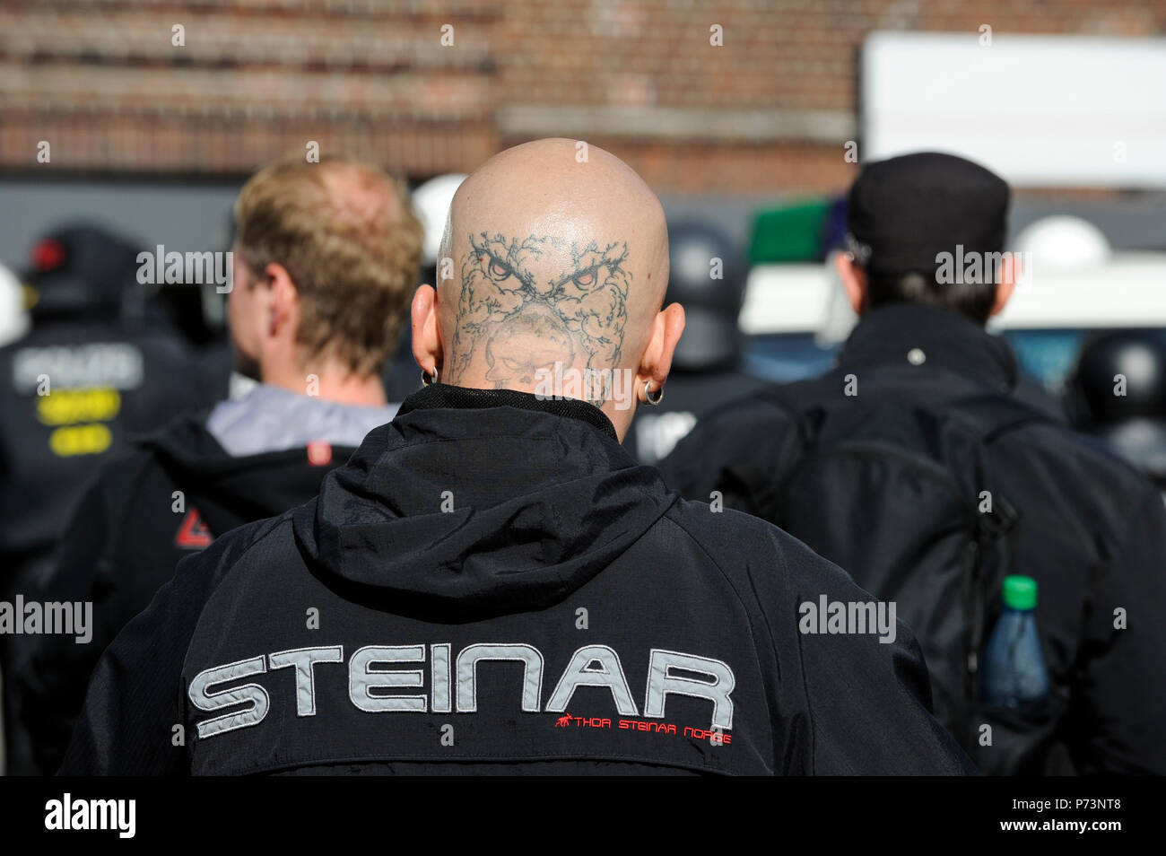 Germany, rally of Nazi and right extremists groups in hamburg, skin head in Thor Steinar Norge branded clothes, with tattooed head, eagle owl and death head Stock Photo