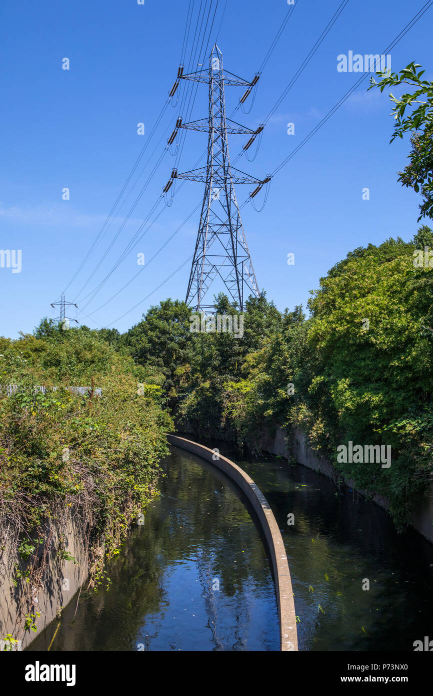 A view of Electricity Pylons looming over the River Lea in Tottenham, London, UK. Stock Photo