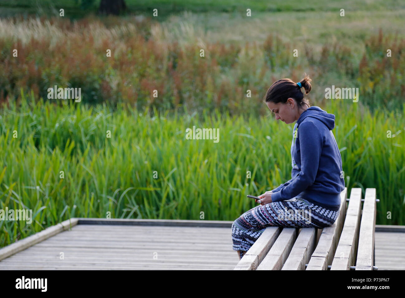 Woman sat on bench in Hilbert & Grosvenor Park Stock Photo