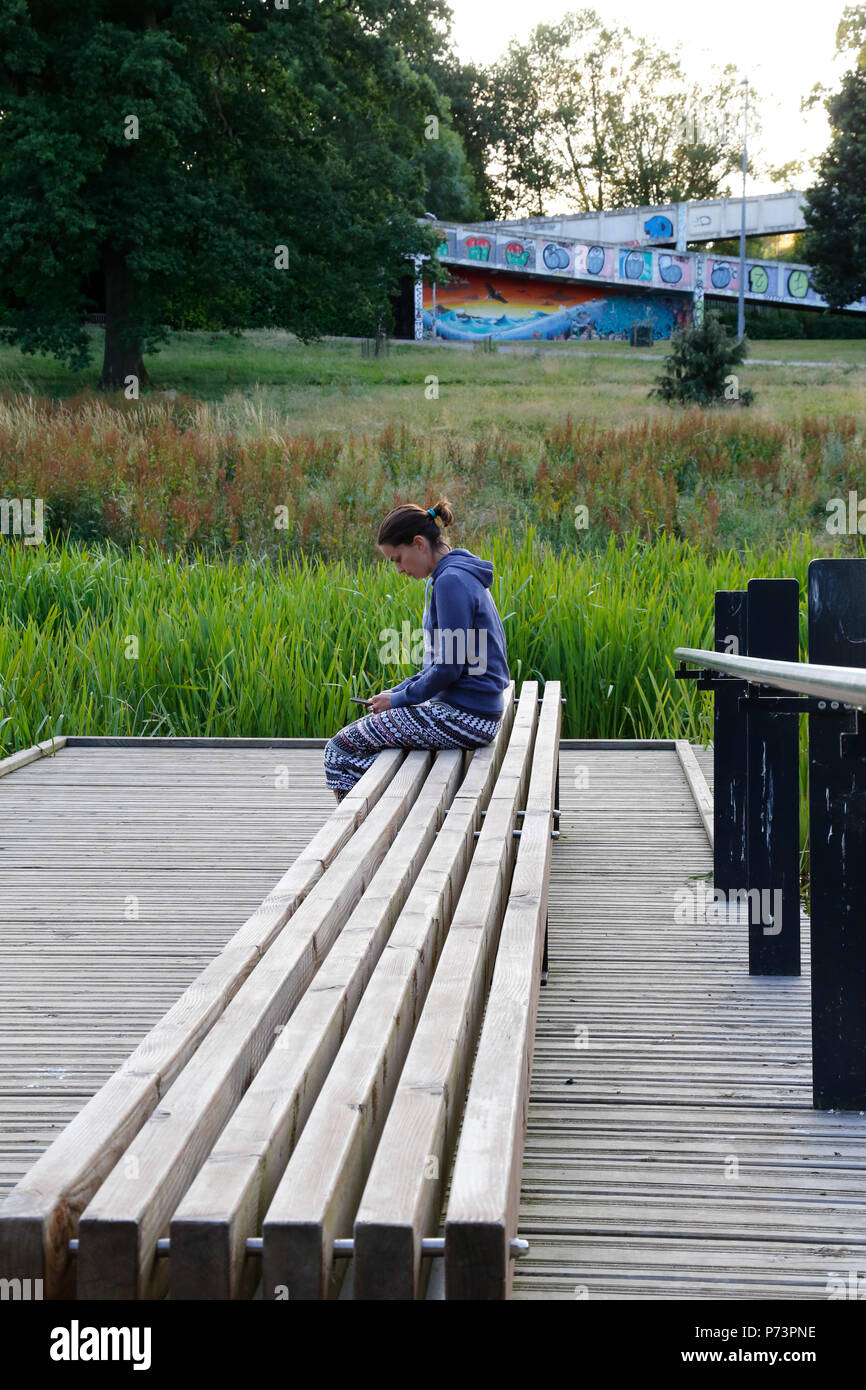 Woman sat on bench in Hilbert & Grosvenor Park Stock Photo