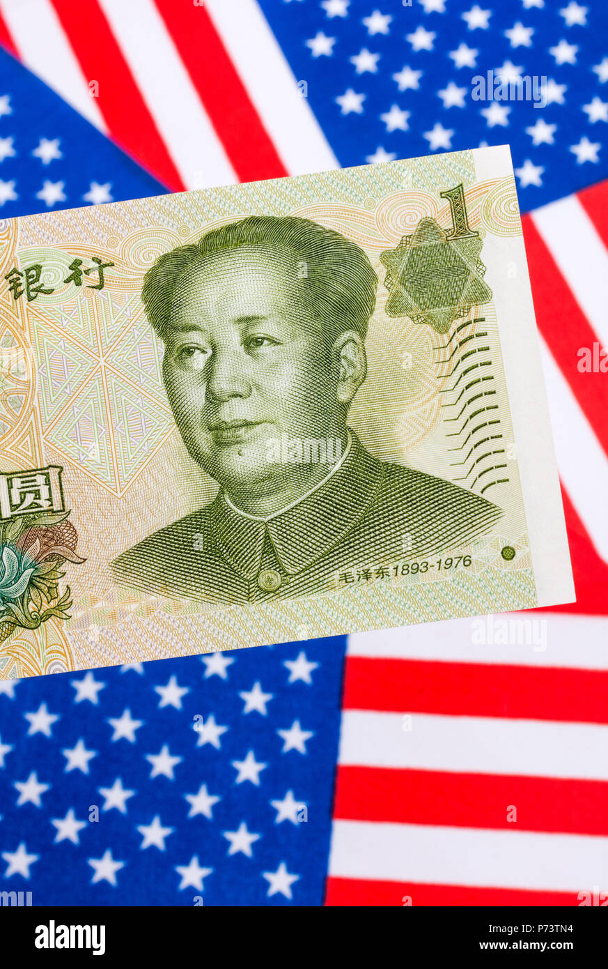 US flag / Stars and Stripes with 1 Yuan Chinese Banknote - metaphor US-China trade war / trade dispute / Trump steel tariffs, Renminbi Yuan weakness. Stock Photo