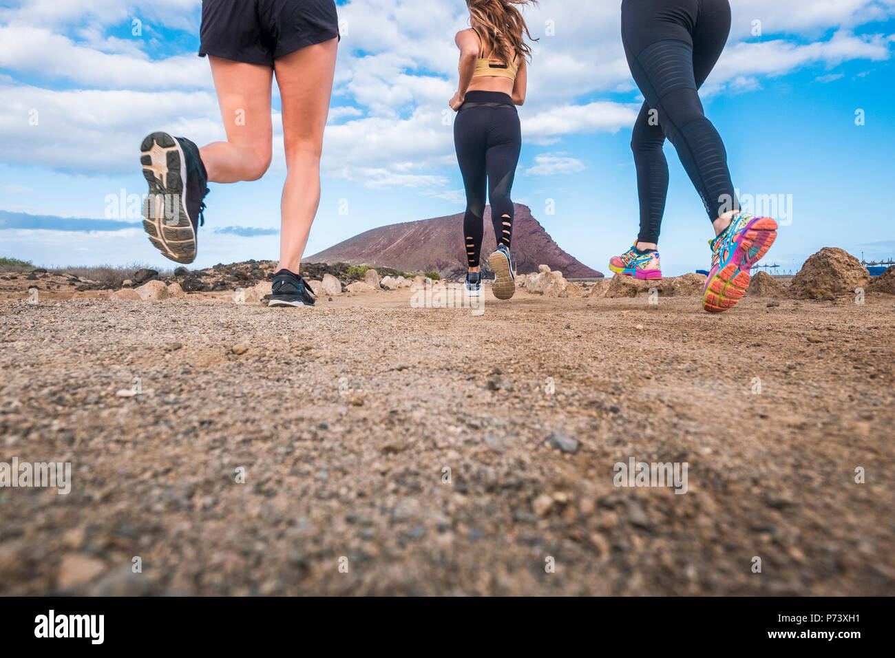 Healthy female runner stretching legs on mountain trail