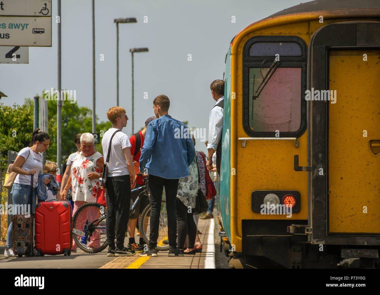 Passengers getting on a diesel commuter train on Platform 2 at Rhoose Cardiff International