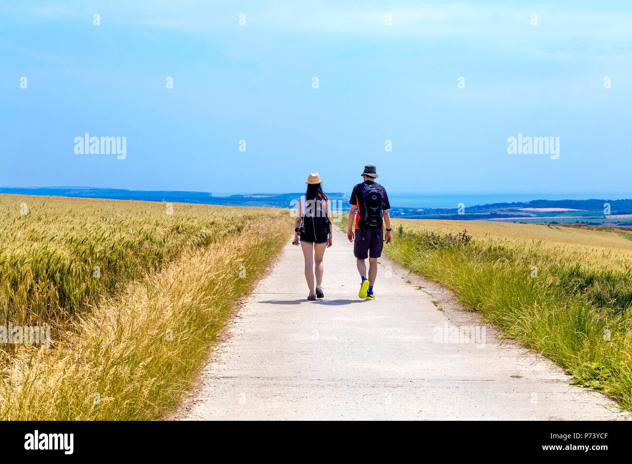 Two people / couple hiking down the South Downs Way in the South Downs National Park, UK Stock Photo