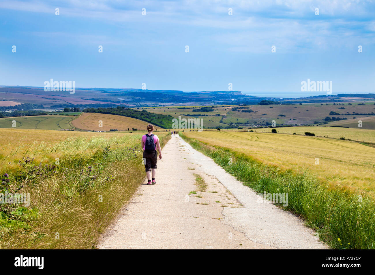 A lone hiker walking down the South Downs Way in South Downs National Park, UK Stock Photo