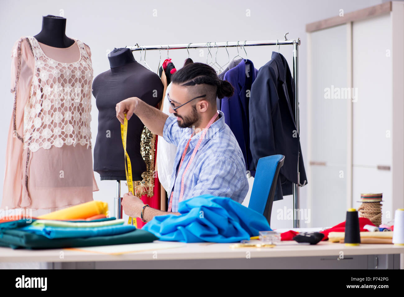 Male tailor working in the workshop on new designs Stock Photo - Alamy