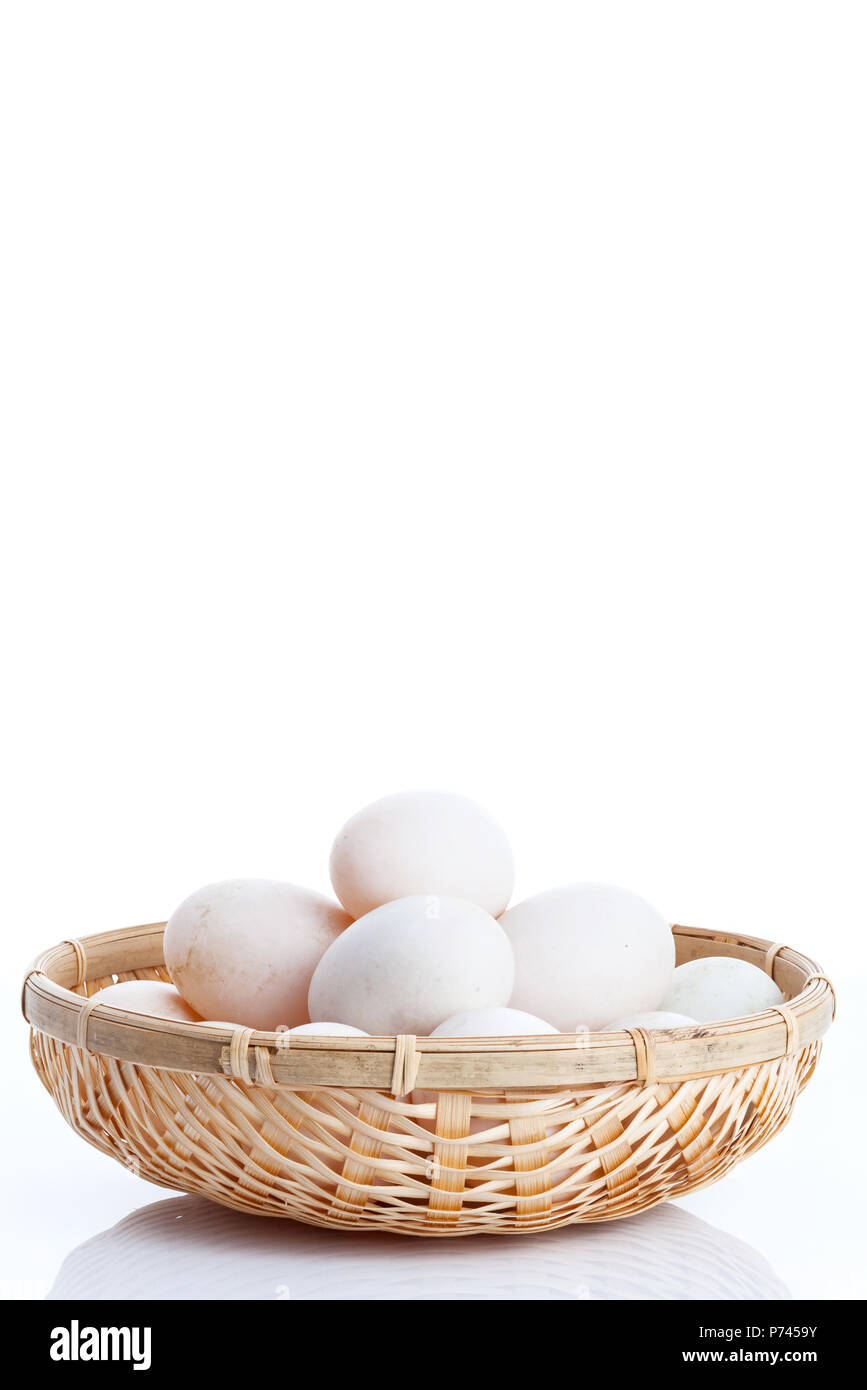Raw dirty duck eggs in the bamboo bowl basket on white background Stock Photo
