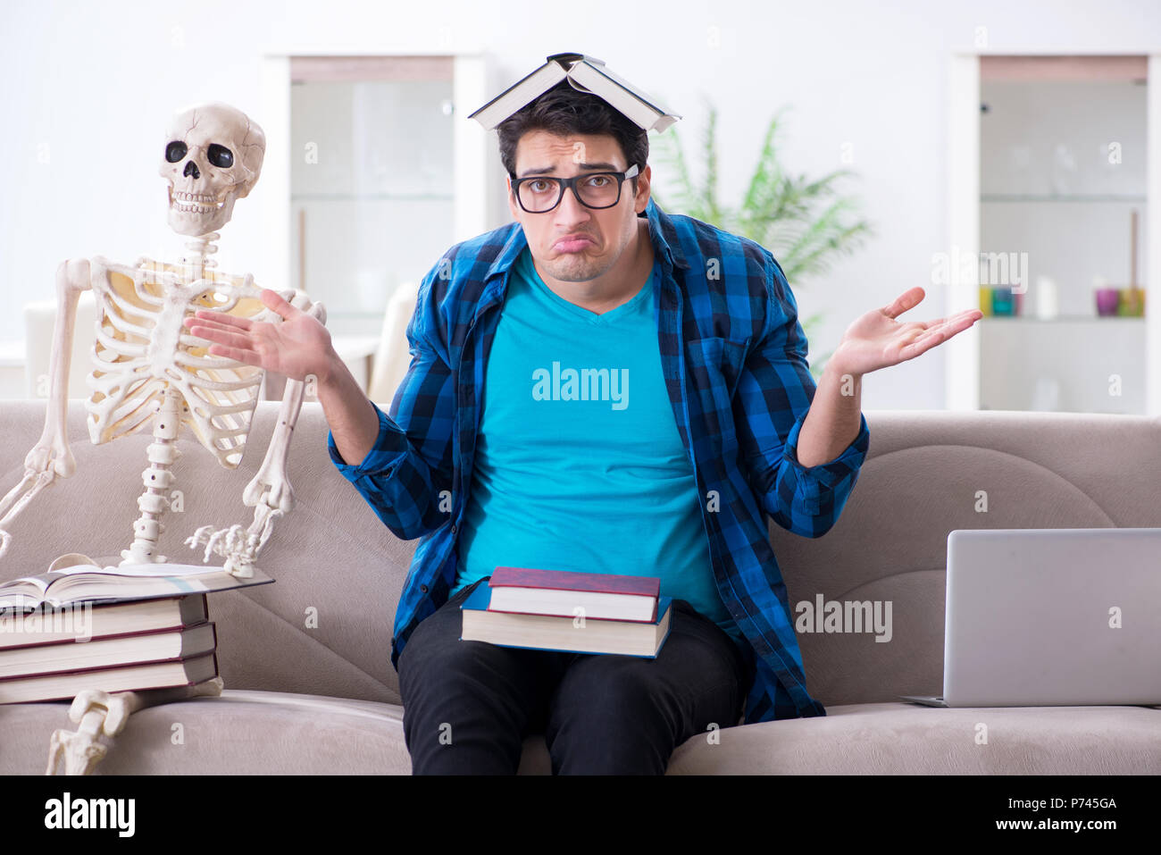 Student studying with skeleton preparing for exams Stock Photo