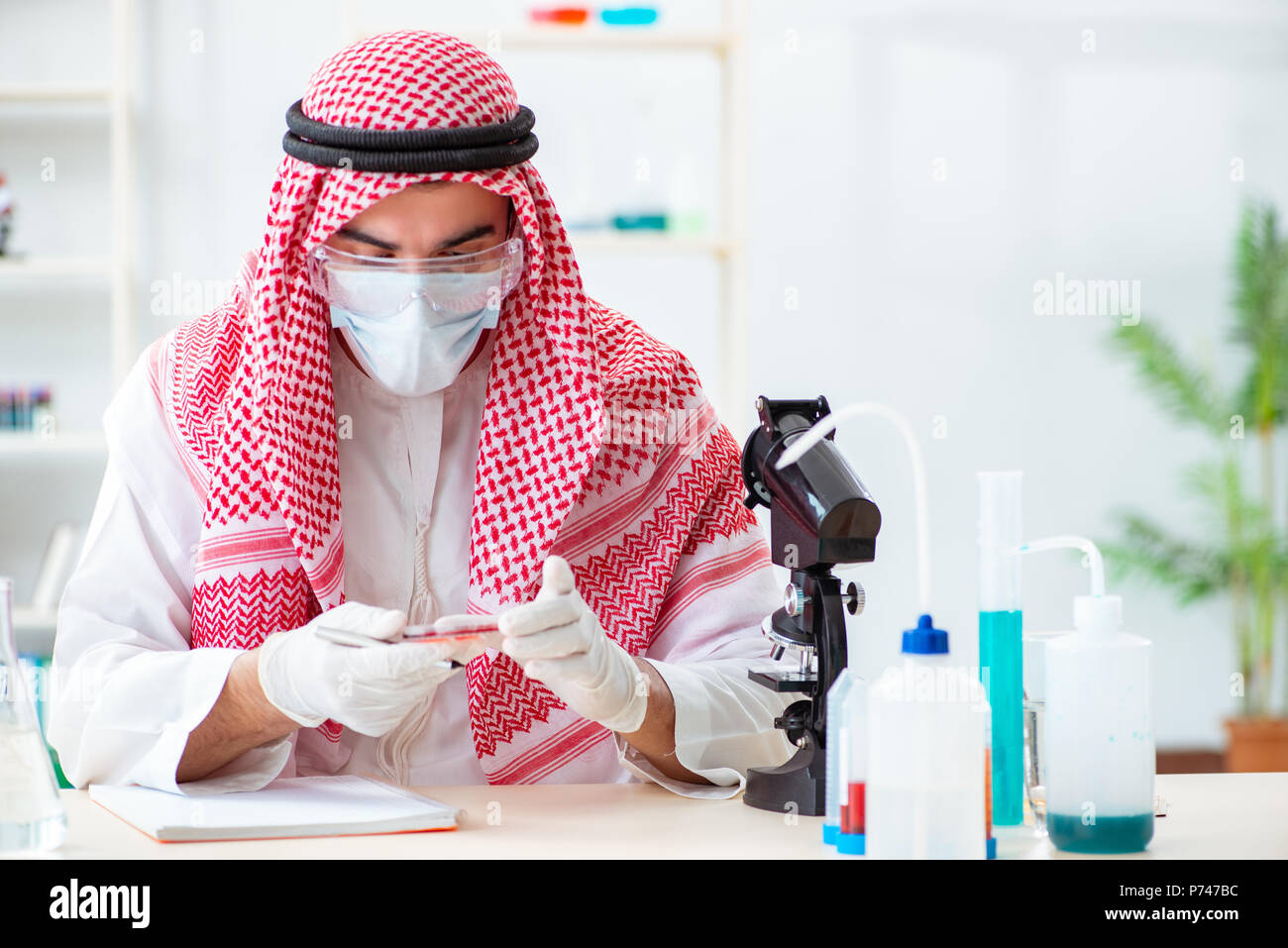 Arab doctor chemist studying new virus in lab Stock Photo