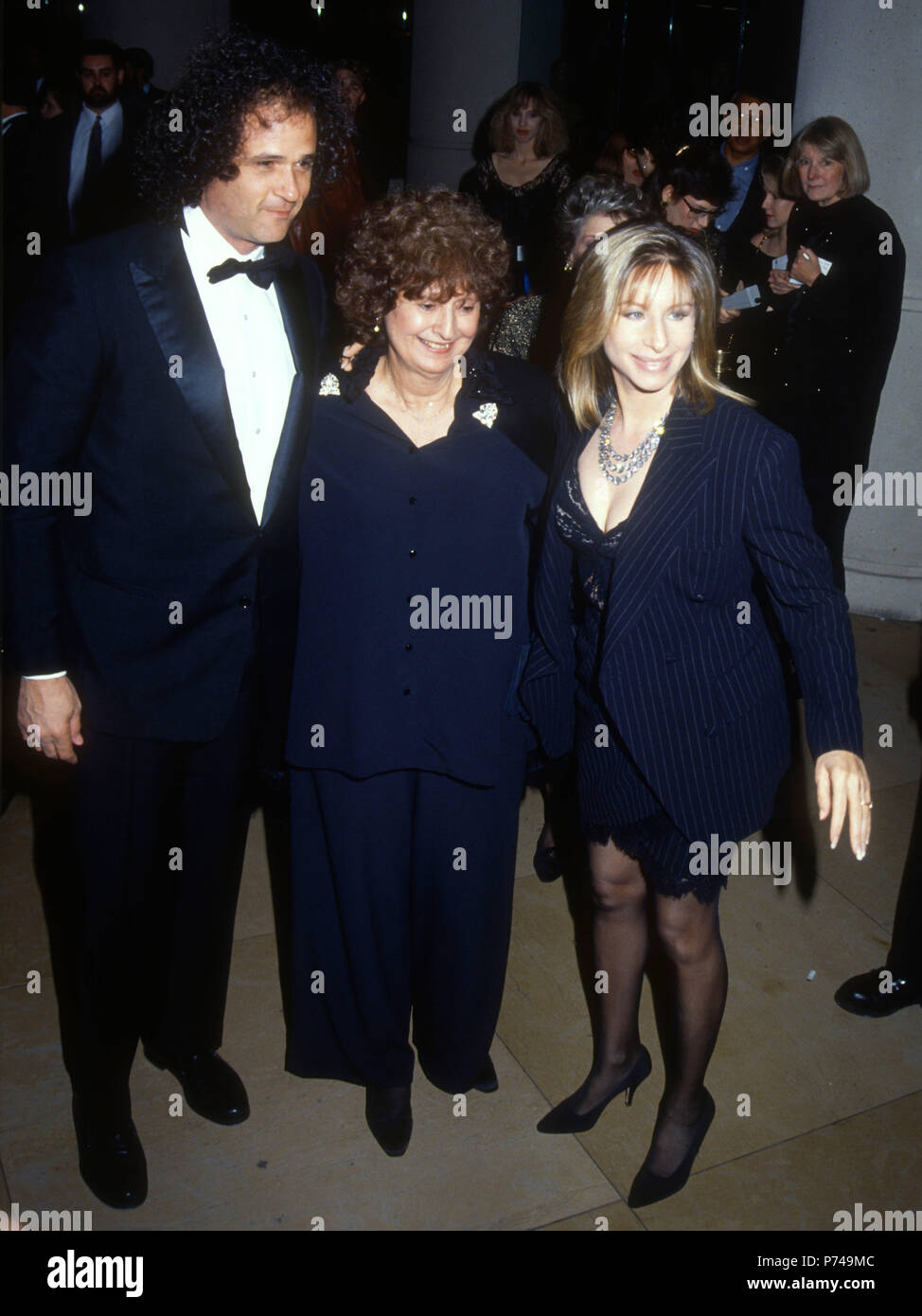 BEVERLY HILLS, CA - JANUARY 18: (L-R) Composer Richard Baskin, guest and Singer/actress Barbra Streisand attend the 49th Annual Golden Globe Awards on January 18, 1992 at the Beverly Hilton Hotel in Beverly Hills, California. Photo by Barry King/Alamy Stock Photo Stock Photo