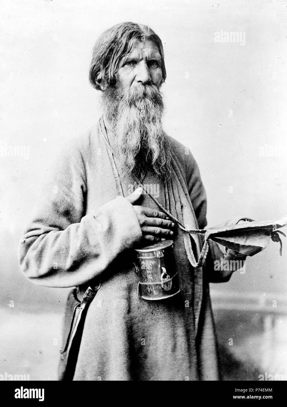 Bearded man, standing, three-quarter length, with box with slot to deposit money, Russia. 1880-1924 Stock Photo