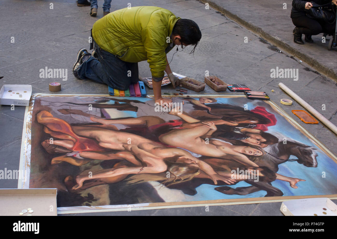 FLORENCE, ITALY - NOVEMBER 22 2015: Street artist in Florence, making art on the asphalt Stock Photo