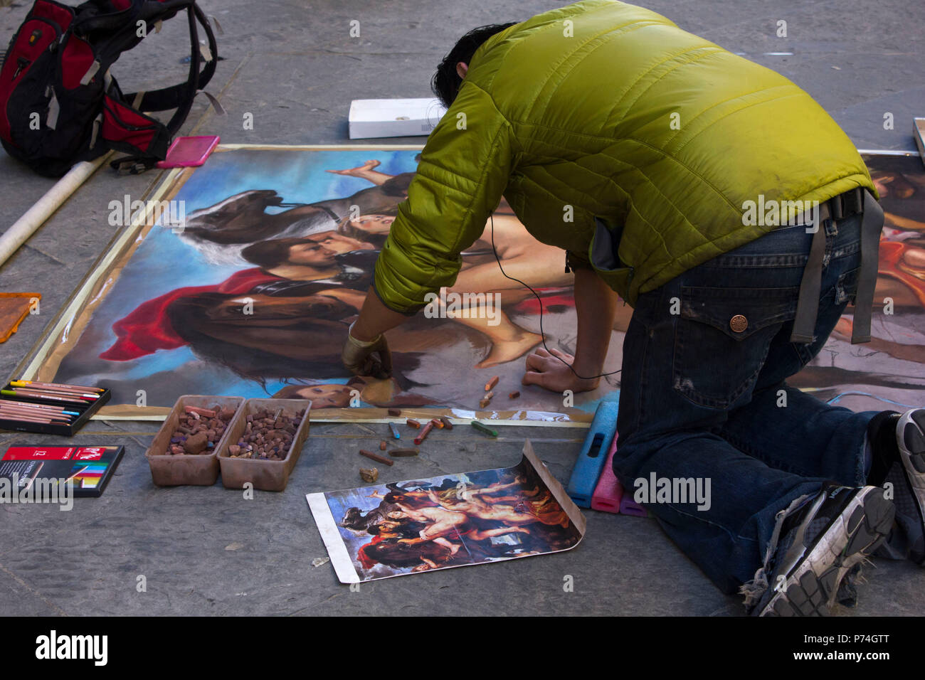 FLORENCE, ITALY - NOVEMBER 22 2015: Street artist in Florence, making art on the asphalt Stock Photo