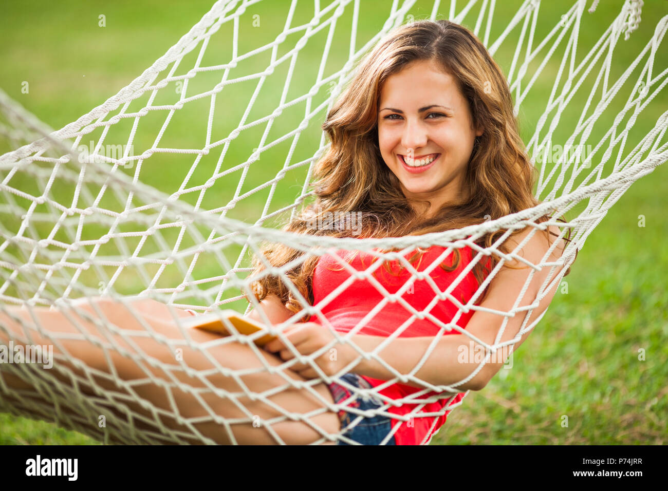 Girl lying in hammock and reading a book Stock Photo - Alamy