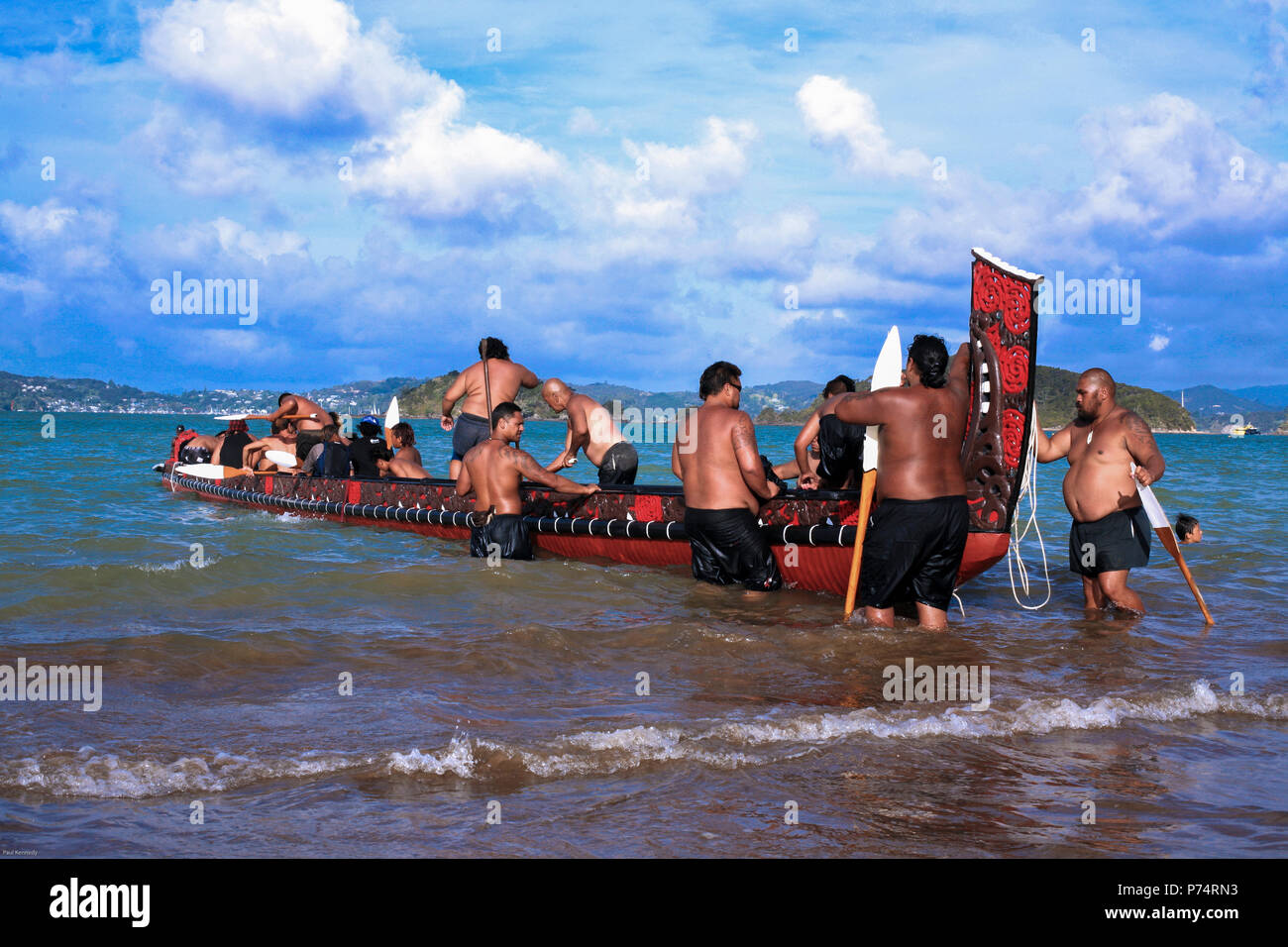 Maori Waka taua (war canoe) launching off beach at Waitangi during Waitangi Day celebrations, Bay of Islands, New Zealand Stock Photo