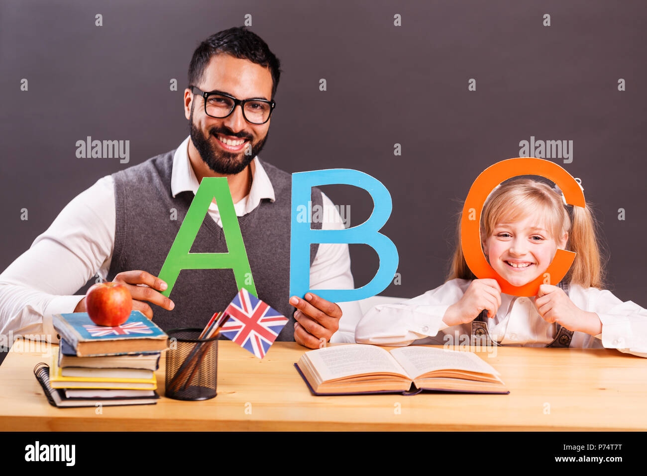 Successful kid student girl smile while playing with English letters with teacher, children language education concept Stock Photo