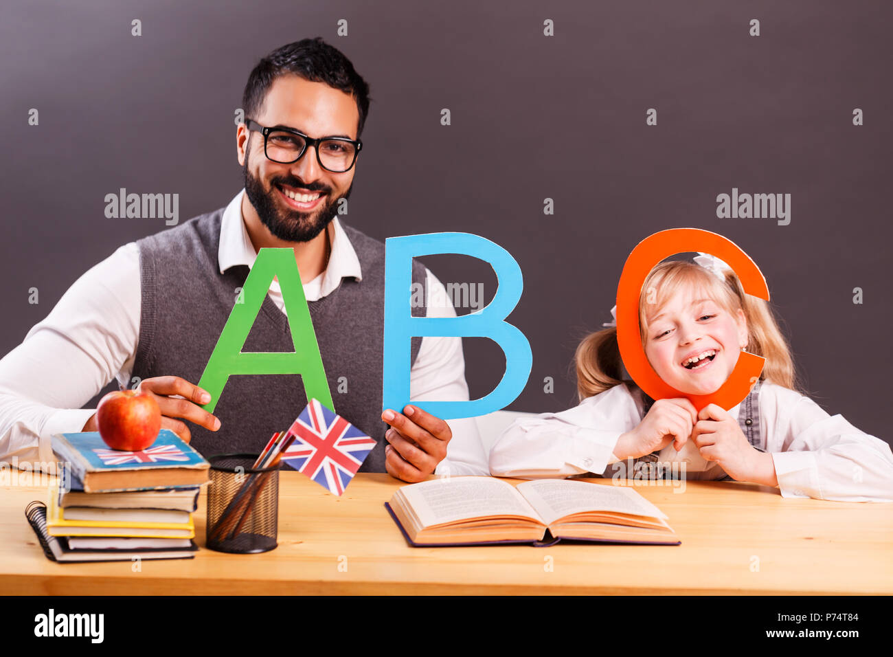 Successful kid student girl smile while playing with English letters with teacher, children language education concept Stock Photo