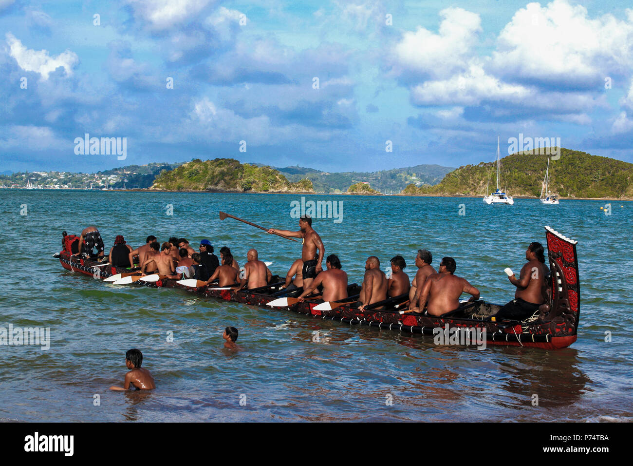 Maori Waka taua (war canoe) launching off beach at Waitangi during Waitangi Day celebrations, Bay of Islands, New Zealand Stock Photo