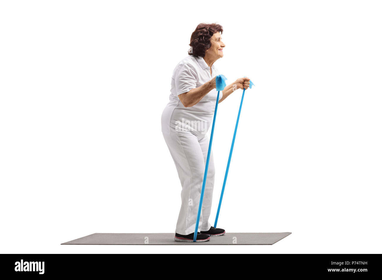 Full length profile shot of an elderly woman working out with a rubber band isolated on white background Stock Photo