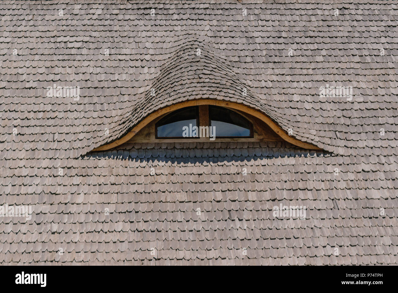 old traditional wood planks tiles roof with eye like window closeup Stock Photo