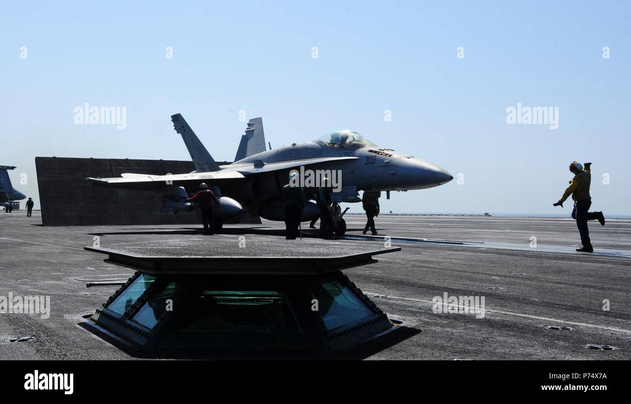 GULF (Sept. 15, 2014) Sailors prepare to launch an F/A-18C Hornet assigned to the Valions of Strike Fighter Squadron (VFA) 15 from the flight deck of the aircraft carrier USS George H.W. Bush (CVN 77). George H.W. Bush is supporting maritime security operations and theater security cooperation efforts in the U.S. 5th Fleet area of responsibility. Stock Photo