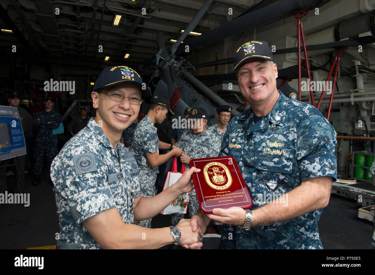 NAVAL BASE, Singapore – (Feb. 9, 2015) – Cmdr. Kendall Bridgewater, commanding officer of LCS Crew 104 presents Rear-Admiral Lai Chung Han, Republic of Singapore Chief of Navy, a token gift after guiding a tour of the littoral combat ship USS Fort Worth (LCS 3) for Lai and his staff. Fort Worth is on a 16-month deployment to the U.S. 7th Fleet area of responsibility in support of the Asia-Pacific rebalance. Stock Photo