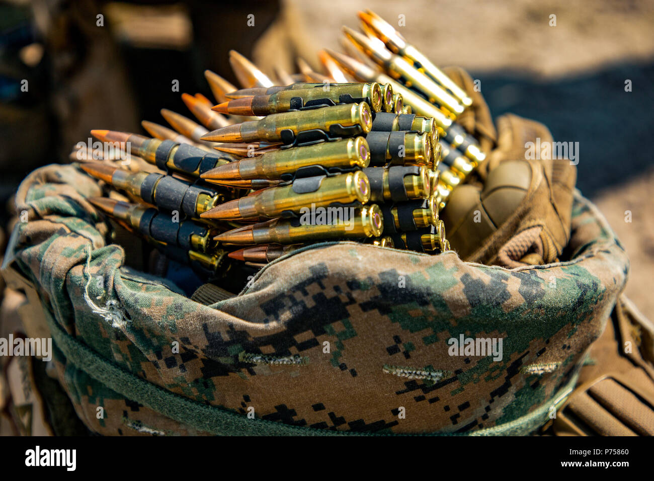 U.S. Marines stage a belt of 7.62 ammunition inside of a kevlar during a squad live-fire range aboard Babadag Training Area, Romania, June 6, 2018. Black Sea Rotational Force Marines conduct live-fire ranges to increase readiness to respond to any situation, Marines train to employ their weapon systems effectively and traverse any terrain in order to build proficiency and confidence when rapidly moving and engaging targets. (U.S. Marine Corps Photo by Cpl. Alexander Sturdivant/Released) Stock Photo