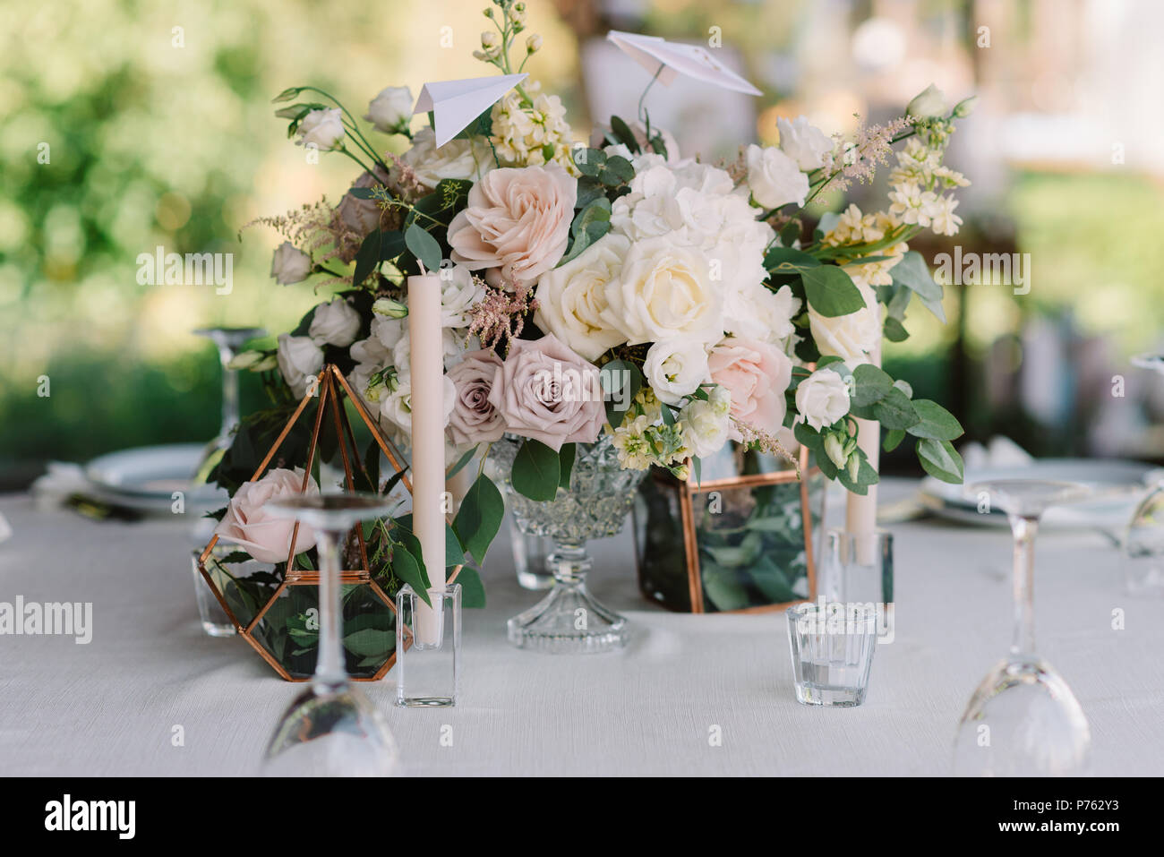 Magnificent, volume bouquets of flowers in high glass vases. Wedding flowers on tables for