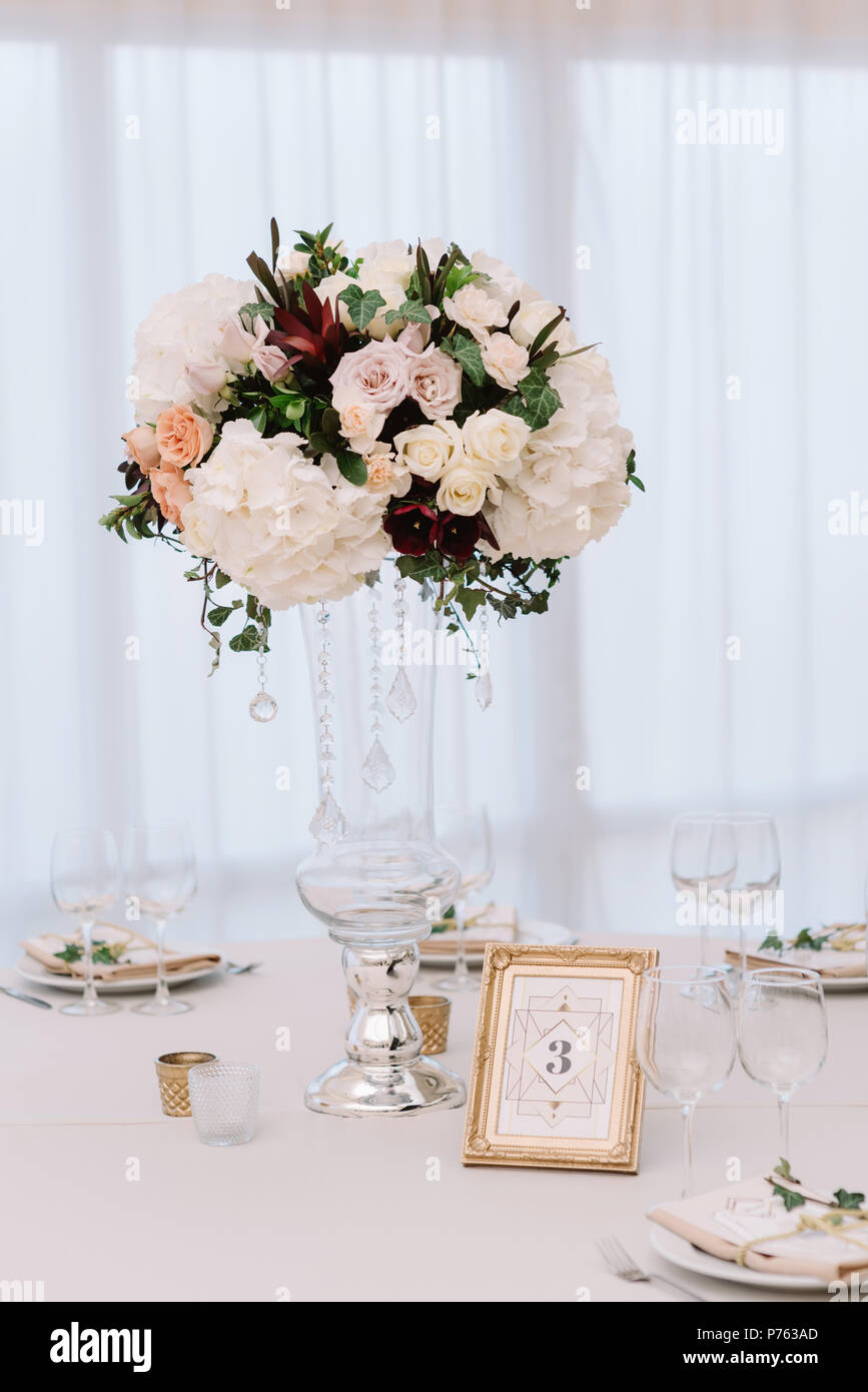Magnificent, volume bouquets of flowers in high glass vases. Wedding