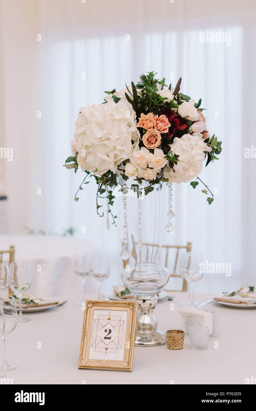 Magnificent, volume bouquets of flowers in high glass vases. Wedding