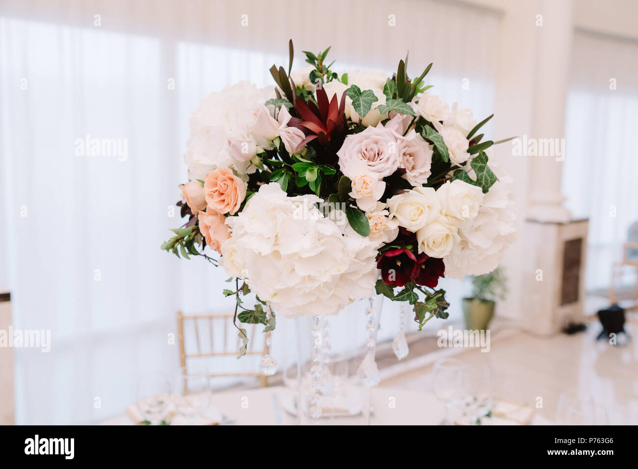 Magnificent, volume bouquets of flowers in high glass vases. Wedding