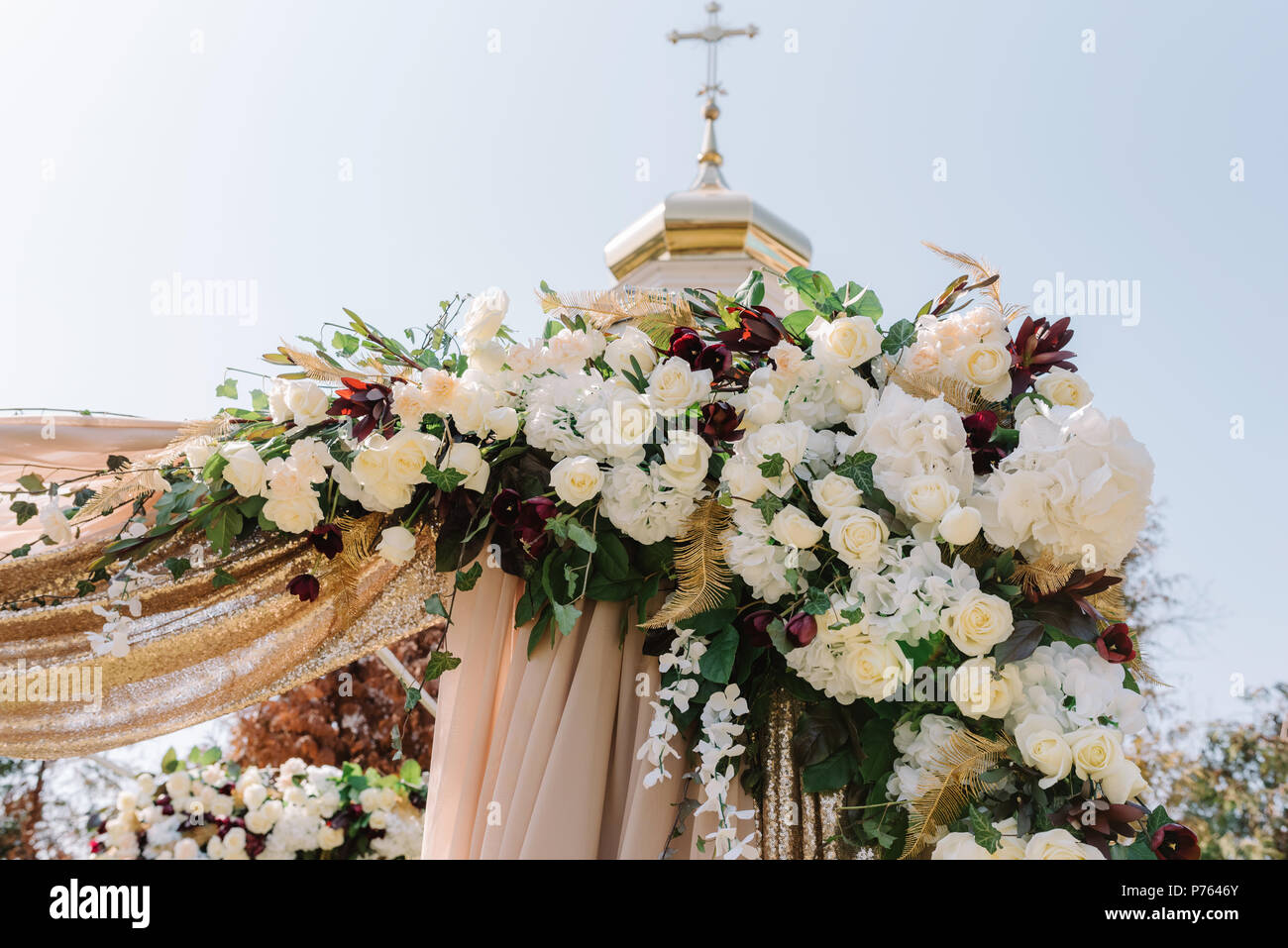 Decorating Of A Wedding Arch In Flowers Golden Fabrics And Greens