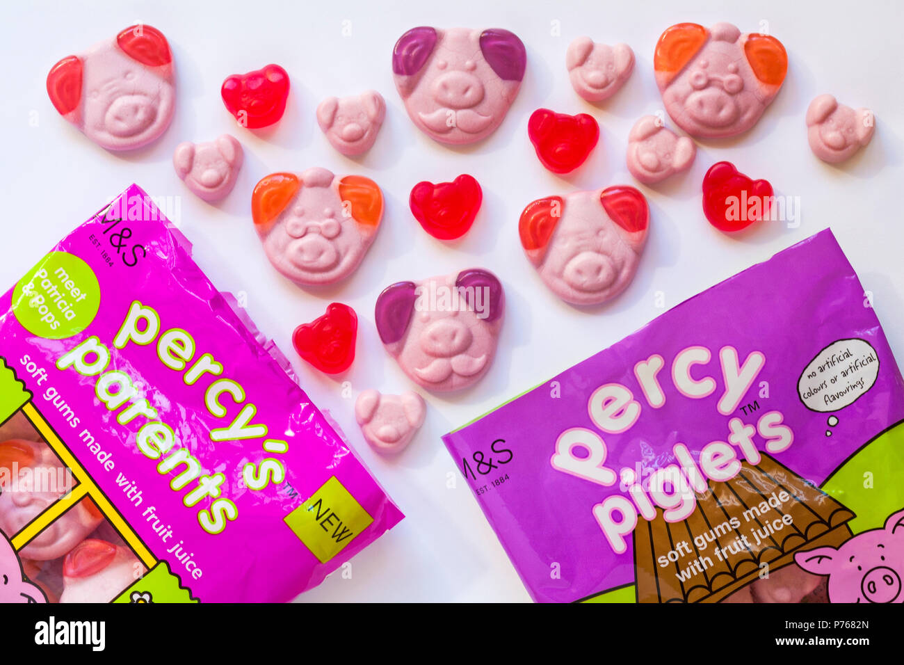 Packets of percy's parents and percy piglets percy pig sweets opened with contents spilled set on white background - soft gums made with fruit juice Stock Photo