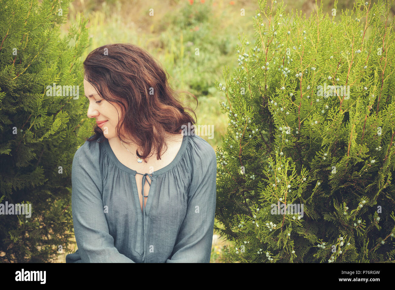 Young adult European woman in garden. Vintage toned profile outdoor portrait Stock Photo