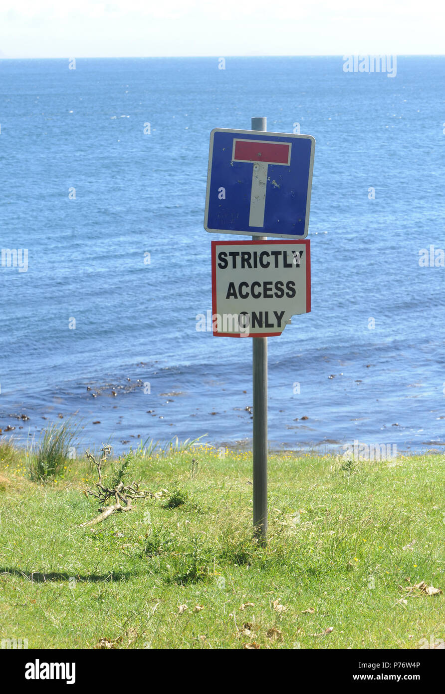 Dead end sign with a ‘Strictly Access Only’ sign on the edge of the sea beneath the basalt cliffs of Fair Head. Ballycastle, Antrim, Northern Ireland. Stock Photo