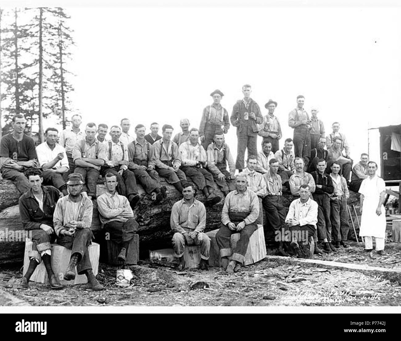 . English: Logging crew and cook at camp, The Eufaula Company, ca. 1921 . English: Caption on image: The Eufaula Co. C. Kinsey Photo, Seattle. No. 34 PH Coll 516.1165 The Eufaula Company was in business ca. 1915 to ca. 1926. Eufaula is a former logging town which is now practically deserted two miles north of the Columbia River and four miles northwest of Longview in western Cowlitz County. In the late 1880s the town was named by Jefferson D. Brock, an employee of a logging company, for his home town in Alabama. Subjects (LCTGM): Loggers; Cooks; Benches----Washington (State); Lumber camps--Was Stock Photo