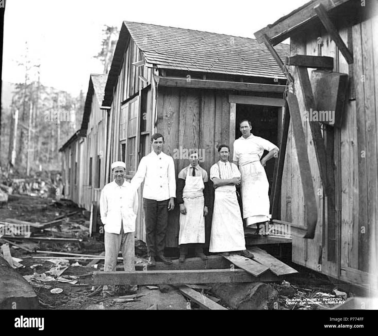 . English: Mess hall crew at camp, Puget Sound Mill and Timber Company, Twin, ca. 1921 . English: PH Coll 516.3006 Puget Sound Mill & Timber Company cut its first lumber at Port Angeles in 1914. Logging operations were located at Twin. The mill was out of business by 1927. Twin is a small settlement on the Strait of Juan de Fuca 20 miles west of Port Angeles at the mouth of Twin River in north central Clallam County named for its position at the mouths of West Twin and East Twin rivers. It wasn't until the turn of the century when the Chicago, Milwaukee, St. Paul and Pacific Railroad was built Stock Photo